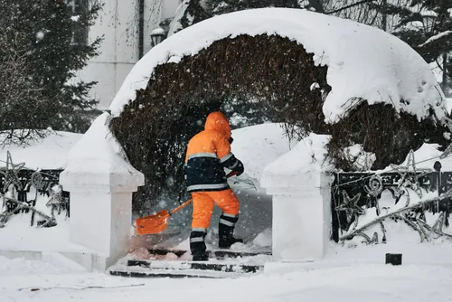 Ein Mitarbeiter beim Schneeschaufeln